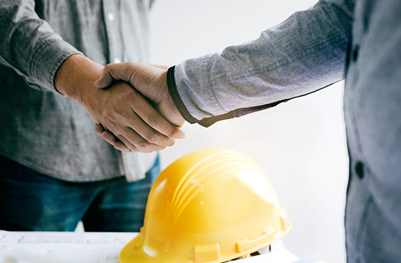 Two men shake hands after going through the claims management process.